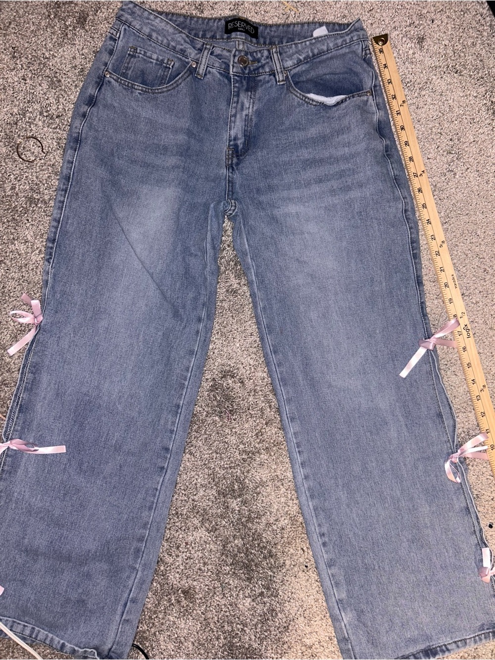 Size 9 woman’s Reserved blue jeans with pink ribbon bows on the sides